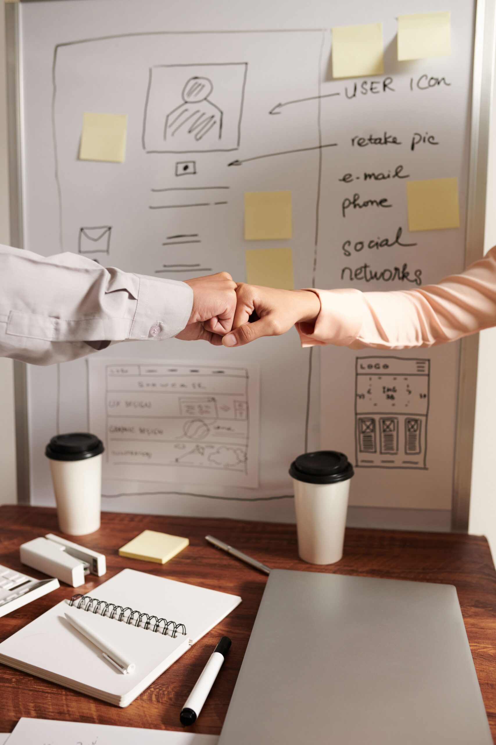 ui ux designers giving each other fist bump after finishing meeting new mobile application 2